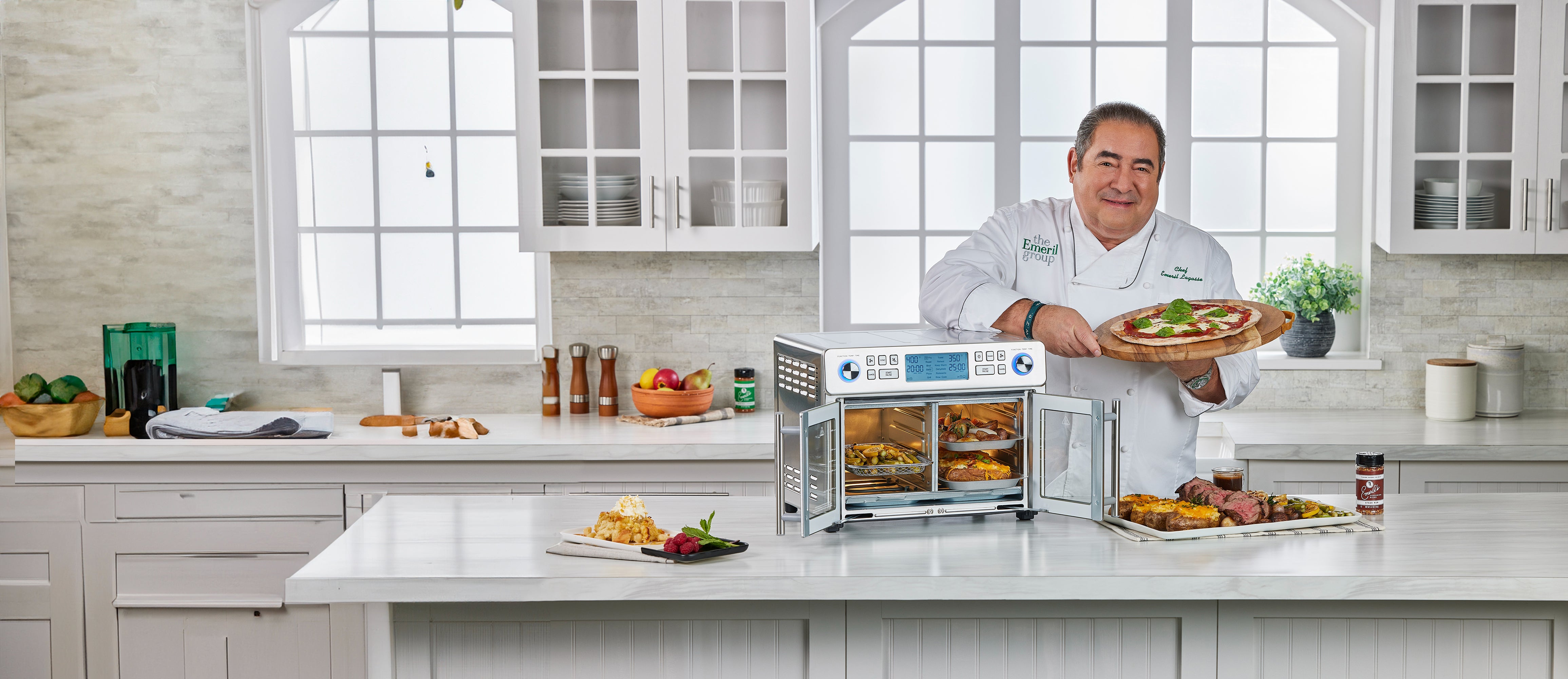 Chef Emeril Lagasse in a kitchen with a air fryer oven displaying a dish.